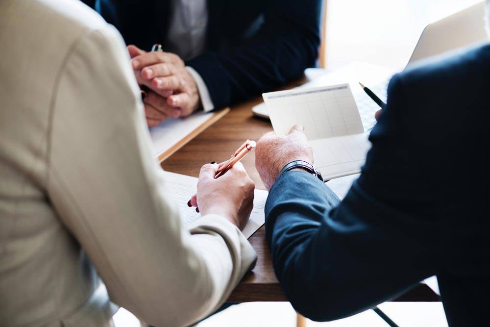 group of business people sitting at table reviewing documents